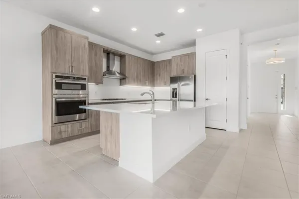 a kitchen with kitchen island white cabinets and stainless steel appliances