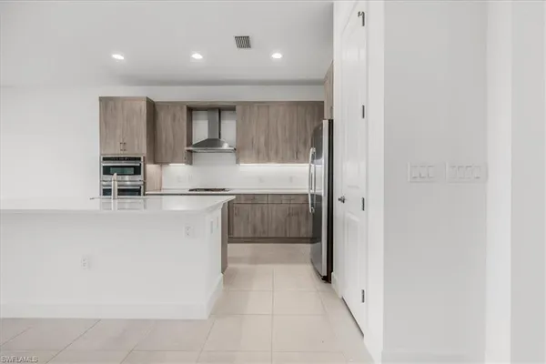 a kitchen with kitchen island white cabinets and stainless steel appliances