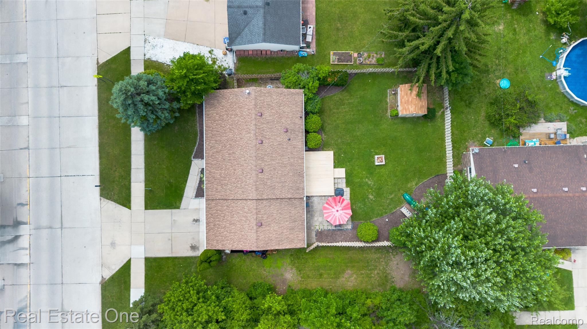 44220 Saltz Road Canton, MI 48187 - Photo 27 of 31 Expansive rear yard featuring a rectangular patio, a fire pit, and mature trees