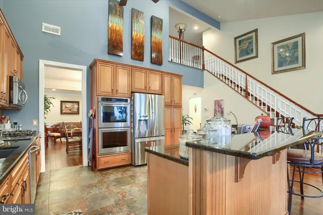 a view of kitchen with stainless steel appliances granite countertop cabinets and a window