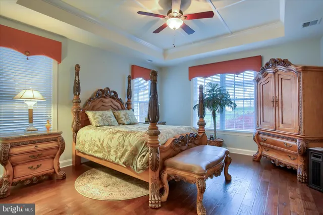 a view of a hallway with wooden floor and a bathroom