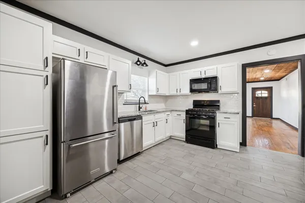 a kitchen with stainless steel appliances a refrigerator stove microwave and sink