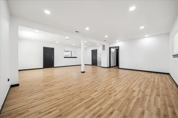 a view of an empty room with wooden floor