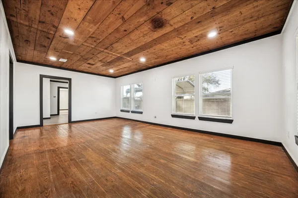 a view of empty room with wooden floor