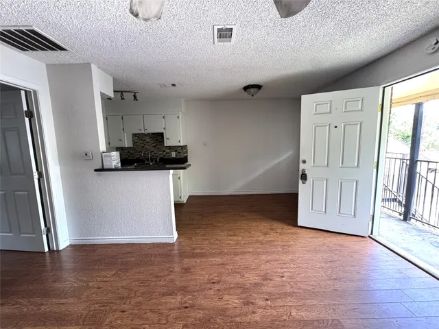 a view of a kitchen with a sink refrigerator and wooden floor