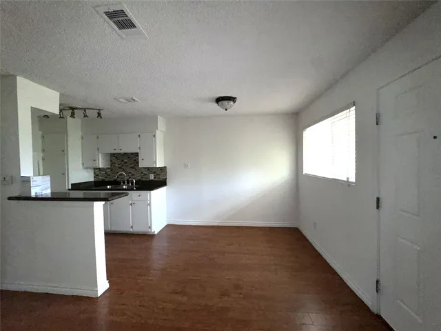 a kitchen with stainless steel appliances granite countertop a sink a stove top oven a counter space and cabinets