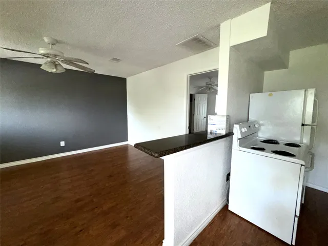 a kitchen with granite countertop a sink cabinets and stainless steel appliances