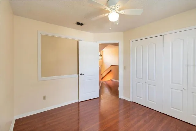 an entryway to room with wooden floor and fan
