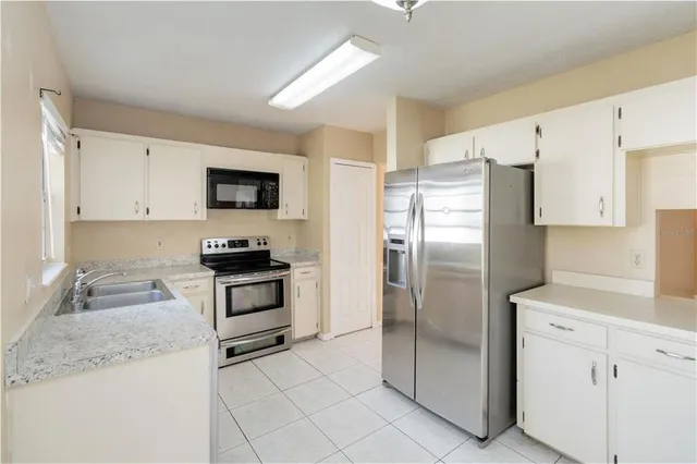 a kitchen with stainless steel appliances granite countertop a refrigerator sink and stove