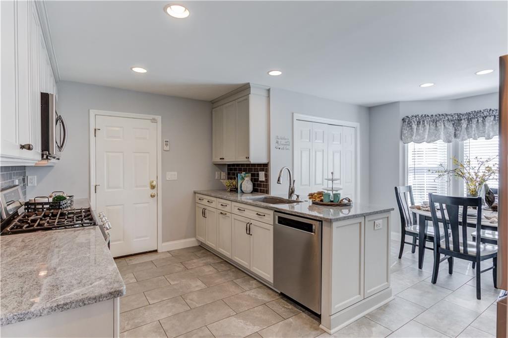 3220 Governors Court Duluth, GA 30096 - Photo 12 of 48 a kitchen with stainless steel appliances granite countertop a stove a sink a refrigerator and island