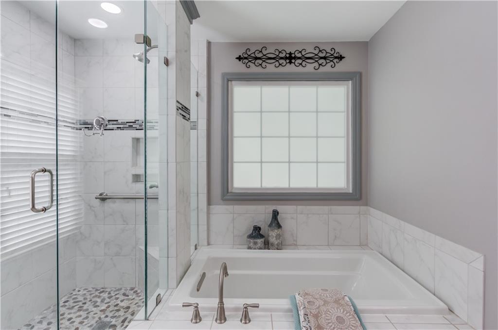 3220 Governors Court Duluth, GA 30096 - Photo 23 of 48 a bathroom with a bathtub a shower a sink and a window