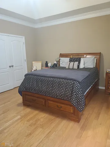 a bed sitting in a bedroom next to a cabinet
