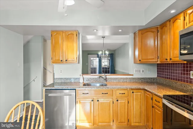a kitchen with granite countertop a sink stainless steel appliances cabinets and a counter top space
