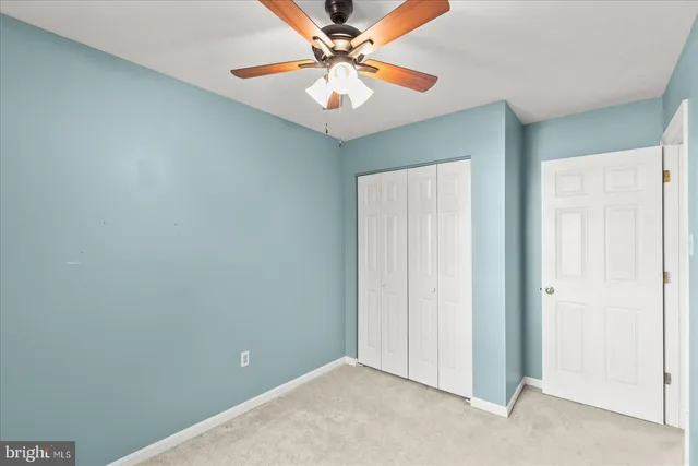 an empty room with closet and fan