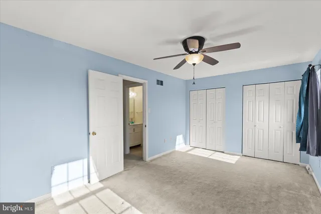 a view of a livingroom with a chandelier fan and windows