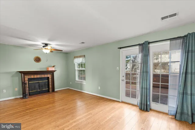 wooden floor fireplace and windows in an empty room