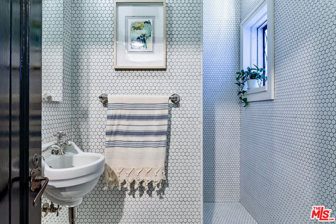 3701 Shannon Road Los Angeles, CA 90027 - Photo 37 of 54 a bathroom with a sink and mirror with bathtub