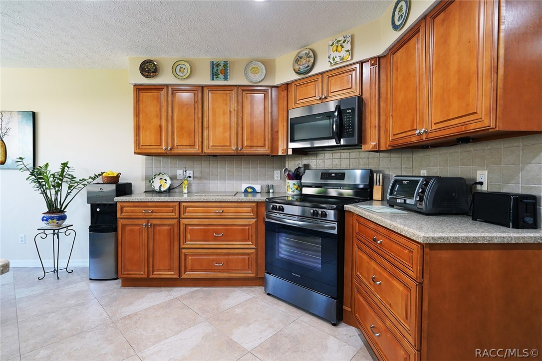 800 Balmoral Court Inverness, FL 34453 - Photo 18 of 72 a kitchen with stainless steel appliances granite countertop a stove top oven a sink dishwasher and cabinets with wooden floor