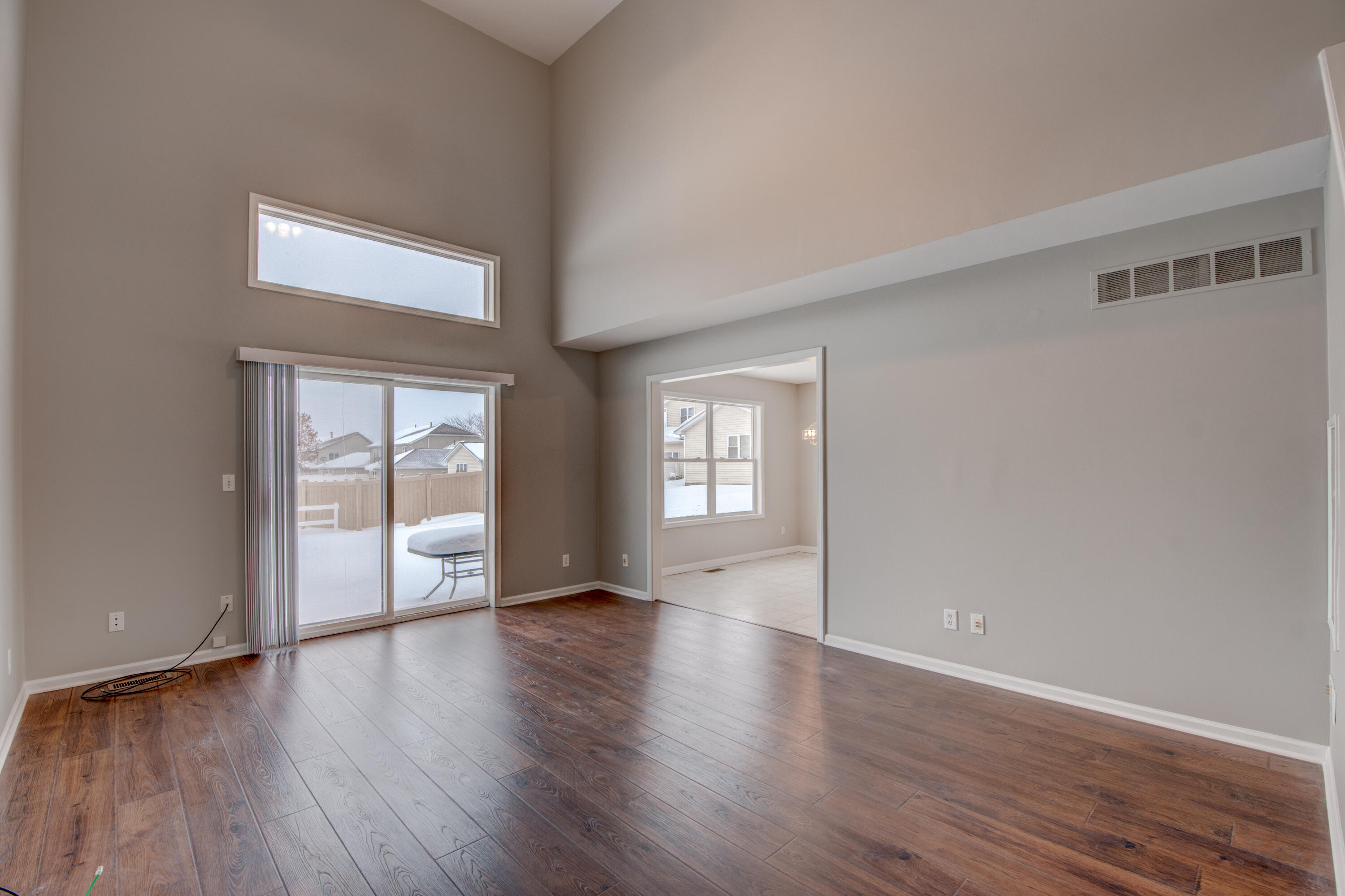 7736 East 108th Avenue, Unit C Crown Point, IN 46307 - Photo 6 of 28 a view of an empty room with wooden floor and a window