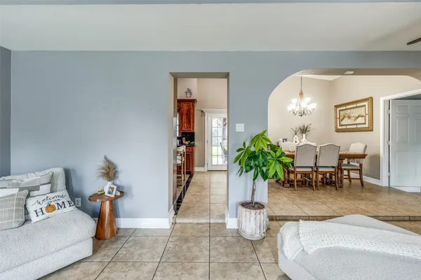 a living room with furniture flowerpot and a chandelier