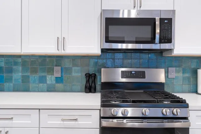 a stove top oven sitting inside of a kitchen