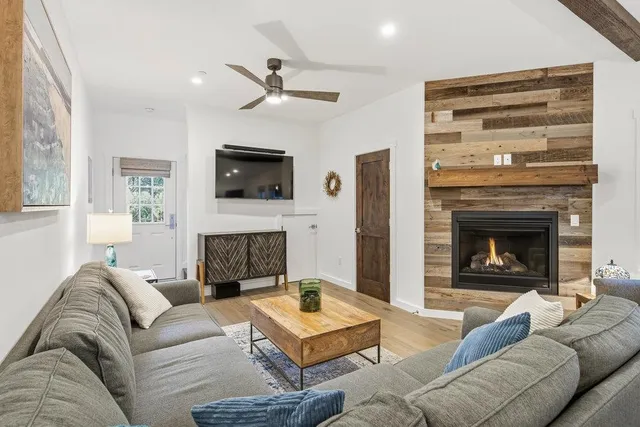 a living room with furniture a flat screen tv and a fireplace