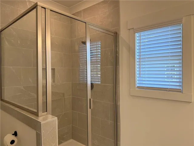a bathroom with a shower and a glass door