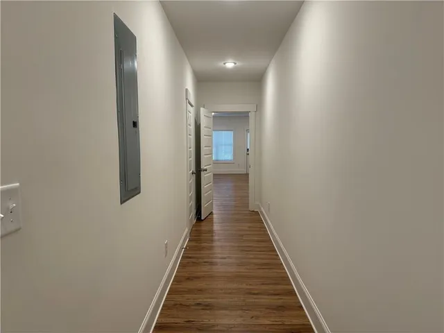 a view of a hallway with wooden floor and staircase