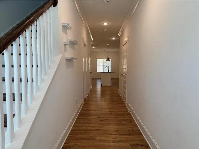 a view of a hallway with wooden floor and staircase