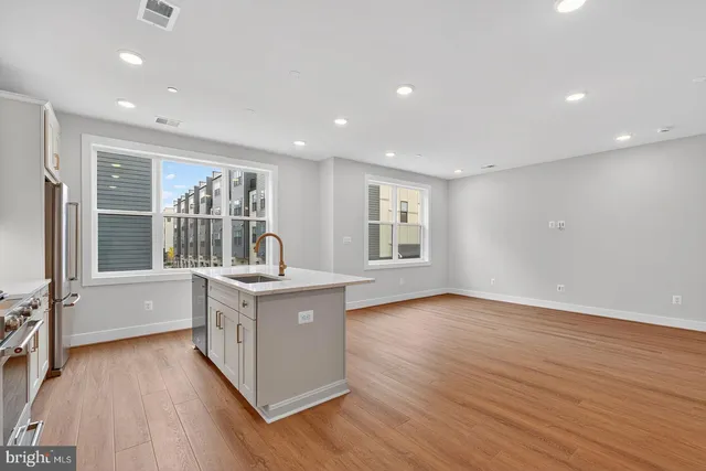 a open kitchen with stainless steel appliances granite countertop a sink stove and wooden floor