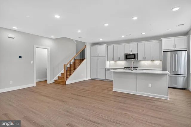 a view of kitchen with wooden floor and electronic appliances