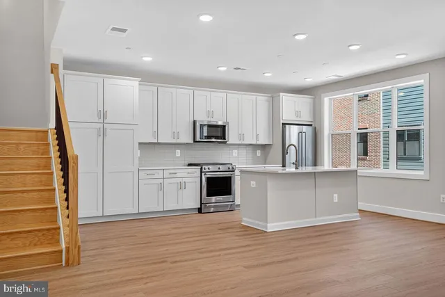 a kitchen with stainless steel appliances granite countertop a stove a sink and a refrigerator