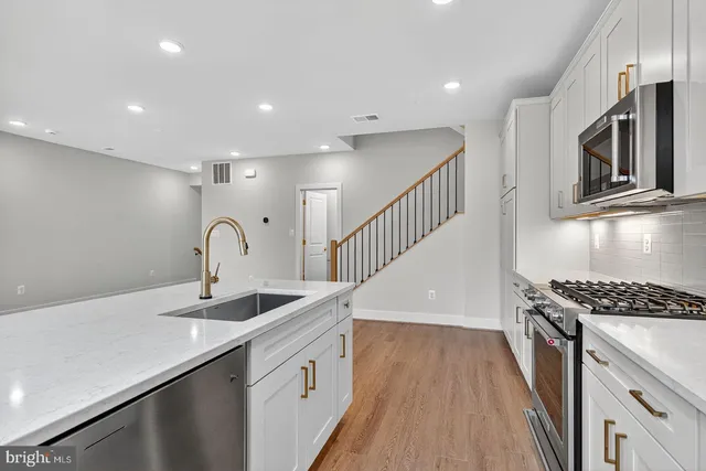 a kitchen with counter top space a sink and stainless steel appliances