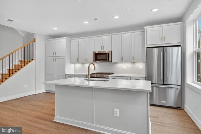 a kitchen with kitchen island a sink stainless steel appliances and cabinets