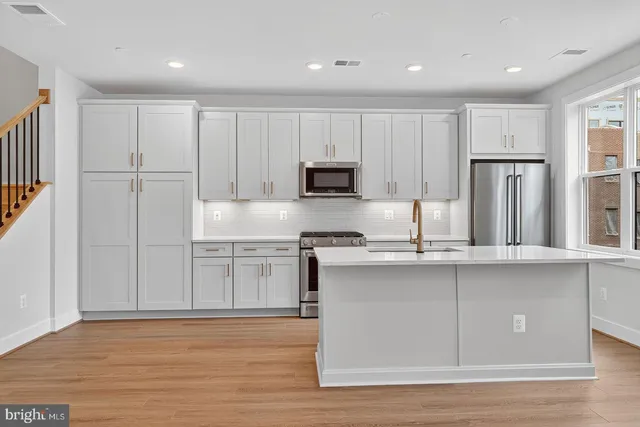 a kitchen with stainless steel appliances granite countertop a stove a sink and a refrigerator