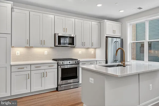 a kitchen with granite countertop white cabinets and stainless steel appliances