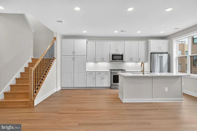 a kitchen with granite countertop a stove top oven and cabinets