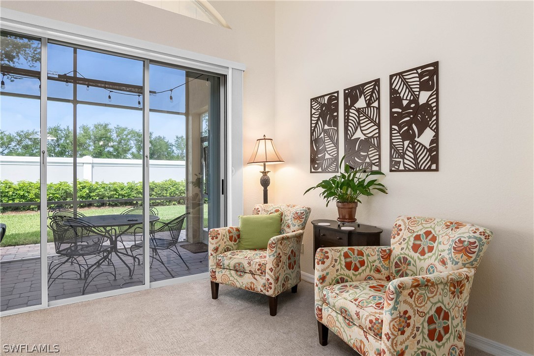 9036 Springview Loop Estero, FL 33928 - Photo 14 of 32 a living room with furniture and a floor to ceiling window