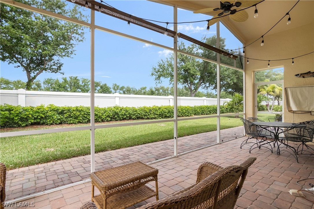 9036 Springview Loop Estero, FL 33928 - Photo 25 of 32 a view of a patio with a table chairs and a yard