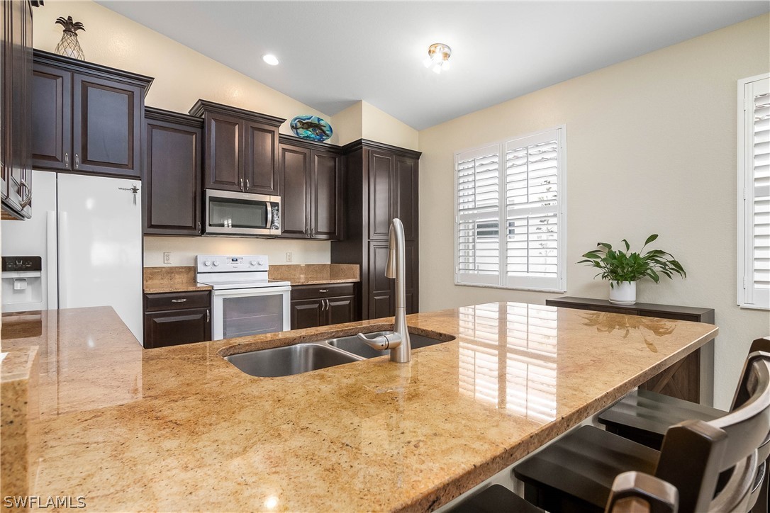 9036 Springview Loop Estero, FL 33928 - Photo 3 of 32 a kitchen with stainless steel appliances granite countertop a stove a sink and a refrigerator