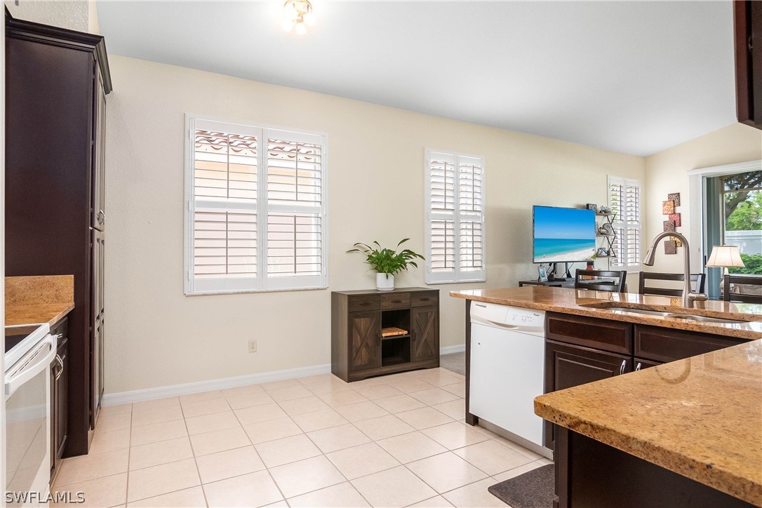 9036 Springview Loop Estero, FL 33928 - Photo 5 of 32 a kitchen with stainless steel appliances granite countertop a stove a sink and a refrigerator