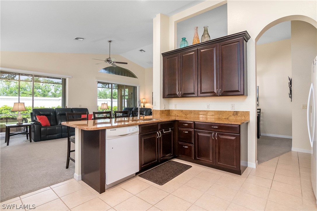 9036 Springview Loop Estero, FL 33928 - Photo 6 of 32 a kitchen with stainless steel appliances granite countertop a stove sink and cabinets
