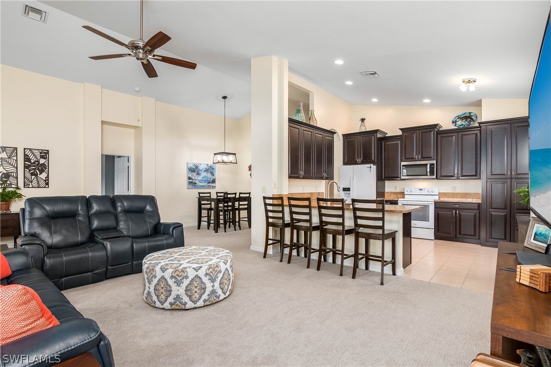 9036 Springview Loop Estero, FL 33928 - Photo 9 of 32 a living room with furniture kitchen view and a chandelier