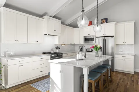 a living room with kitchen island furniture and a chandelier
