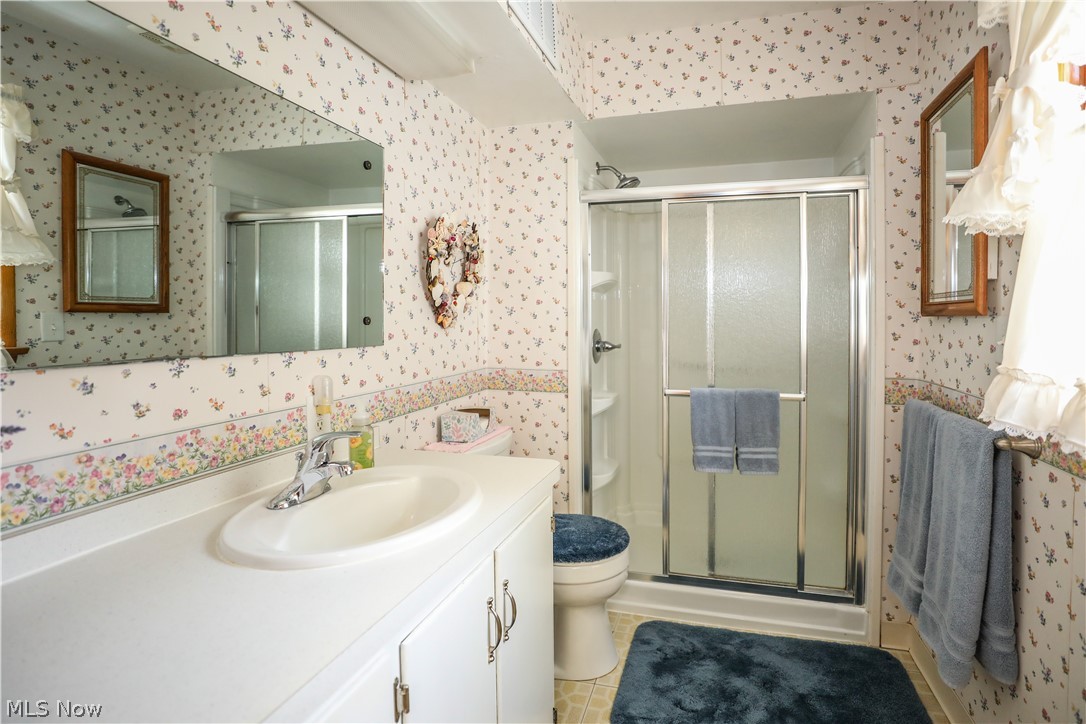 7769 Peck Road Ravenna, OH 44266 - Photo 17 of 50 FF Bathroom with a shower with door, tile flooring, oversized vanity, and toilet