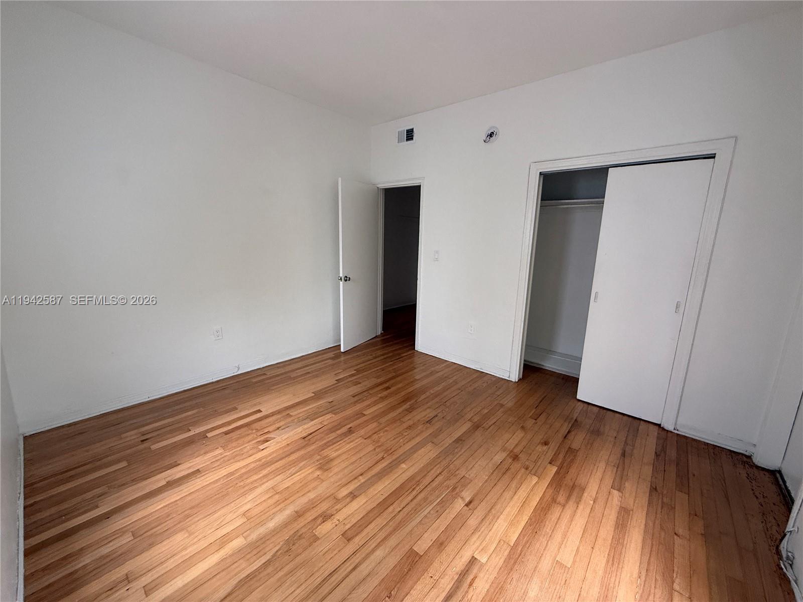 1011 9th Street, Unit 1 Miami Beach, FL 33139 - Photo 11 of 15 a view of an empty room with wooden floor and closet
