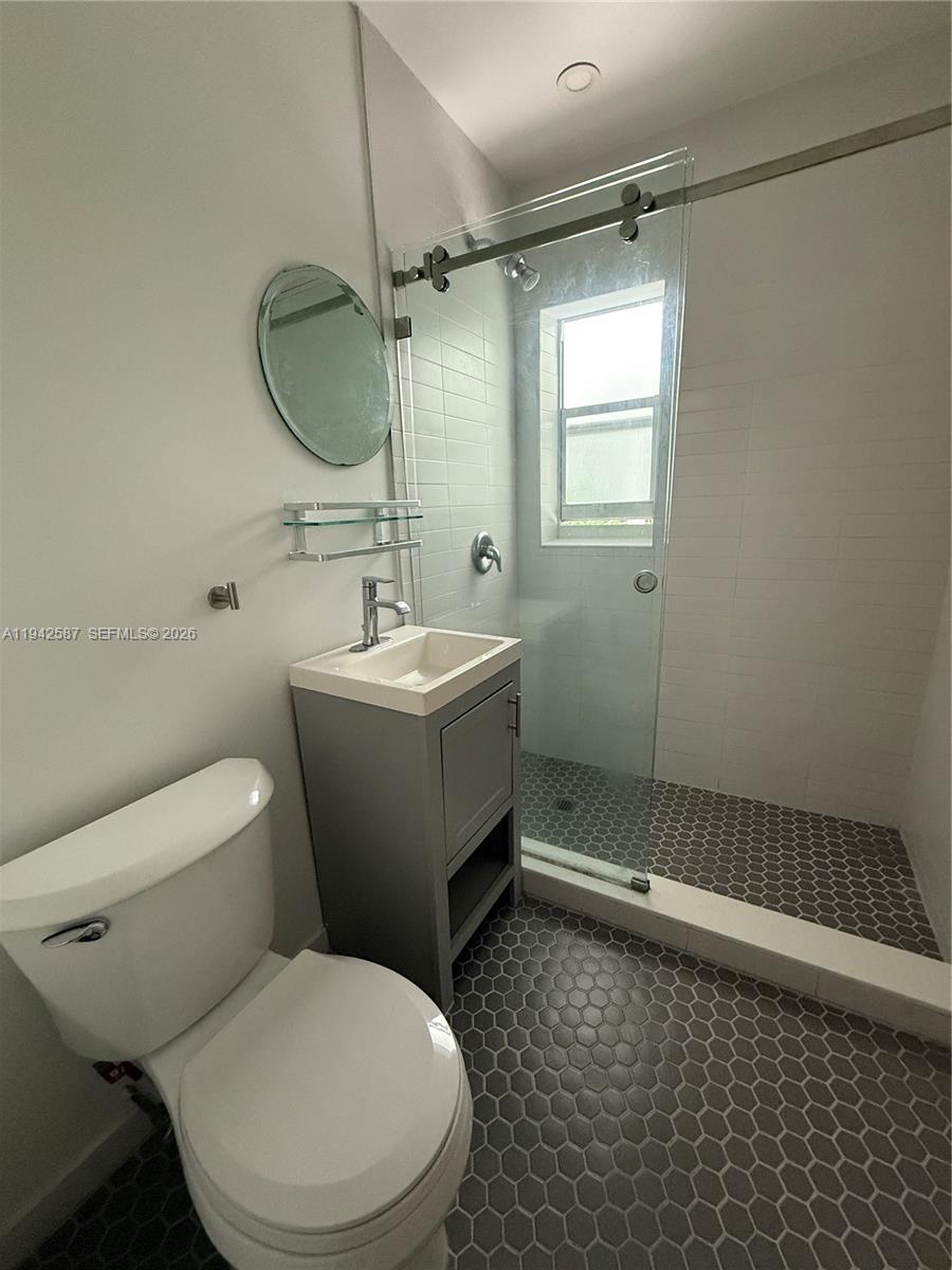 1011 9th Street, Unit 1 Miami Beach, FL 33139 - Photo 9 of 15 a bathroom with a toilet a sink and shower