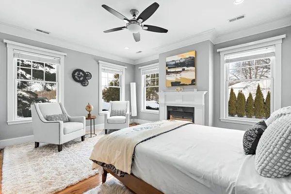 a bedroom with a large bed couch and windows