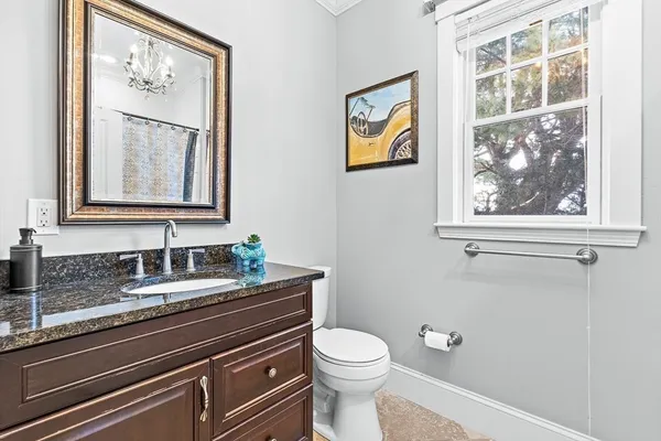 a bathroom with a granite countertop sink mirror and toilet