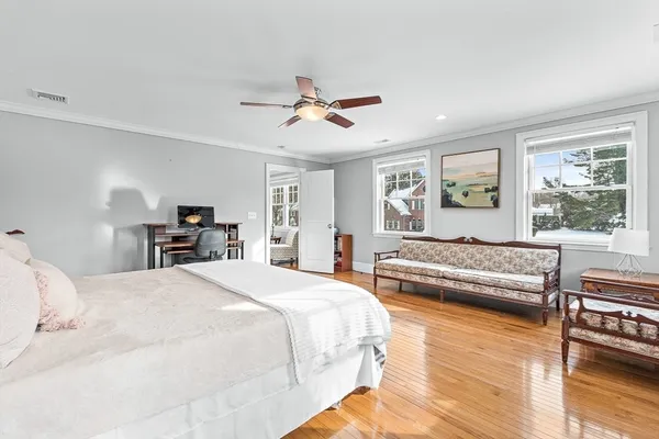 a spacious bedroom with a large bed a chandelier and windows